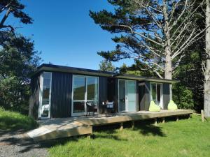 ein schwarzes winziges Haus mit einem Tisch im Gras in der Unterkunft Waihi Gold Alpacas 1 or 2 people in Waihi