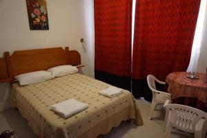 a small bedroom with a bed and a table with at Hostal Camiluz in Nazca