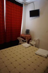 a bedroom with a bed and a table and a television at Hostal Camiluz in Nazca