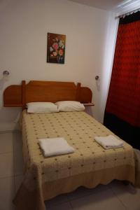 a bedroom with a bed with two towels on it at Hostal Camiluz in Nazca