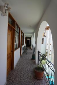 a hallway of a building with chairs and a door at Hostal Camiluz in Nazca