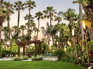 a garden with palm trees and a gazebo at Humphreys Half Moon Inn in San Diego