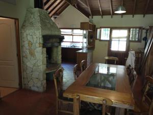 a dining room with a table and a stone fireplace at Casa Valeria del Mar 8 pax in Valeria del Mar