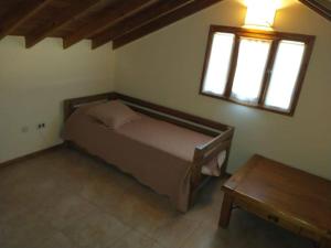 a small bedroom with a bed and a table at Casa Valeria del Mar 8 pax in Valeria del Mar