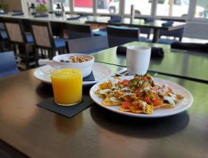 una mesa con dos platos de comida y un vaso de zumo de naranja en Hotel Indigo San Diego - Gaslamp Quarter, an IHG Hotel, en San Diego
