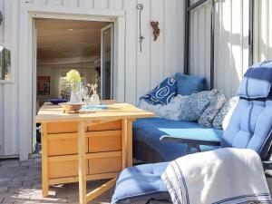 eine Terrasse mit einem Tisch, einem Bett und einem Stuhl in der Unterkunft 8 person holiday home in FAGERFJ LL R NN NG in Bräcke