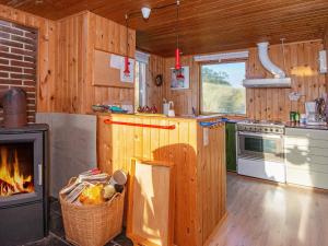 a kitchen with a stove and a fireplace in a cabin at 5 person holiday home in Hvide Sande in Hvide Sande