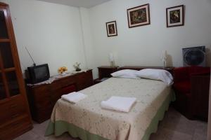 a bedroom with a bed with two towels on it at Hostal Camiluz in Nazca