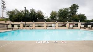 uma grande piscina com cadeiras e uma cerca em Holiday Inn Express Atlanta-Stone Mountain, an IHG Hotel em Stone Mountain