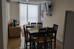 - une salle à manger avec une table, des chaises et un canapé dans l'établissement Elegante apartamento en Condominio Baruc II, à Santa Cruz de la Sierra