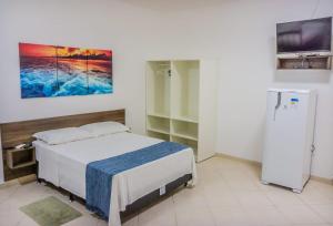 1 dormitorio con 1 cama y una pintura en la pared en Pousada Canasvieiras ABVO, en Florianópolis