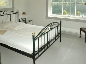 a bedroom with a black bed and a window at 11 person holiday home in Syvde in Myklebost