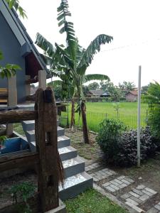 a set of stairs next to a house with a banana tree at JOGLOPARI GuestHouse room 2 bukan untuk pasangan non pasutri in Cepit