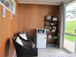 eine Küche mit 2 Stühlen und einem kleinen Kühlschrank in der Unterkunft Waihi Gold Alpacas 1 or 2 people in Waihi
