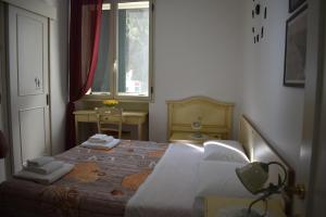 a bedroom with a bed with white sheets and a window at In Riva al Mare in Gela