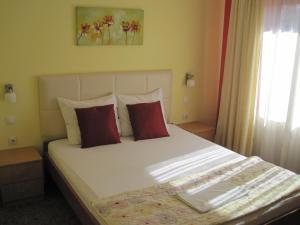 a bedroom with a large bed with red pillows at Brankov Konak in Niš