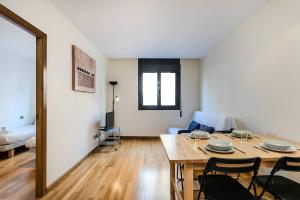 a living room with a table and chairs in a room at Homenfun Barcelona Poble Sec in Barcelona