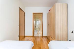 a bedroom with two beds and a bathroom at Homenfun Barcelona Poble Sec in Barcelona