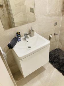 ein Badezimmer mit einem weißen Waschbecken und einem Spiegel in der Unterkunft Apartement Blanc Harfa design in Prag + 45 Fotos