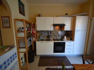a kitchen with white cabinets and a stove top oven at Belvilla by OYO An apartment near the sea in Finale Ligure