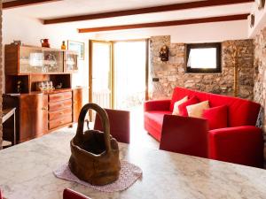 sala de estar con sofá rojo y mesa en Belvilla by OYO Fienile Regoli Quattro, en Crone