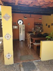 eine Küche und ein Esszimmer mit einem Kühlschrank und einem Tisch in der Unterkunft Pousada Lua Nova in Paraty