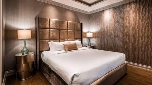 a bedroom with a large bed and two lamps at Georgian Court Hotel, WorldHotels Elite in Vancouver