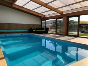 a swimming pool in a house with a glass ceiling at La Mañica in La Vilueña