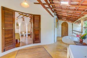 a living room with a door open to a bedroom at Pousada Ilha Verde in Itacaré