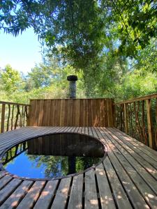 a wooden table with a pond on a wooden deck at Cabañas Huenehue in Panguipulli