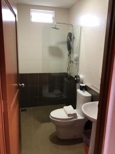 a bathroom with a shower and a toilet and a sink at De Langkawi Resort and Convention Centre in Kuah
