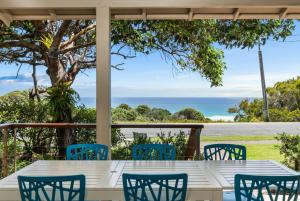 a table and chairs on a porch with a view of the ocean at Beachies 1 in Point Lookout