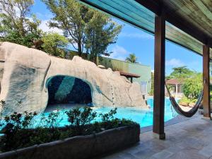 a slide in a pool at a resort at Pernambuco Club House in Guarujá
