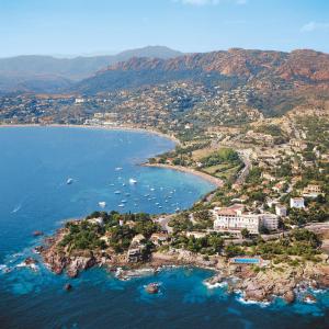 una isla en el océano con barcos en el agua en Logis Hotel l'Esterella en Agay - Saint Raphael