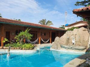 a swimming pool in front of a house at Pernambuco Club House in Guarujá