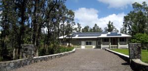 a house with solar panels on the roof at Keaau Place in Keaau