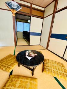 um quarto com uma mesa e dois repousa-pés em KR Apartment in Kanazawa em Kanazawa