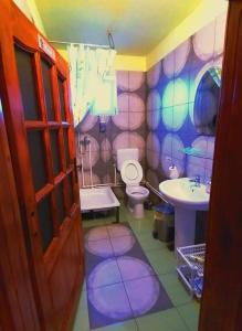 a purple bathroom with a toilet and a sink at Hostel Pascalis Alesd in Aleşd