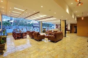 a lobby with couches and a table and chairs at Renai Sreekrishna in Guruvāyūr