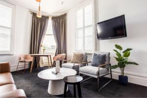 un soggiorno con sedie e TV a parete di Middle Park Hotel a Melbourne