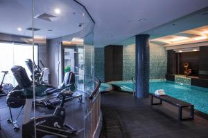 a gym with a swimming pool and exercise bikes at Quay West Suites Melbourne in Melbourne