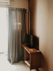 雅加達的住宿－MyStayPro Sentra Timur，客房设有书桌、电视和窗户。