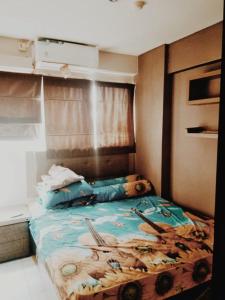 - une chambre avec un lit doté d'une tête de lit en bois dans l'établissement MyStayPro Sentra Timur, à Jakarta