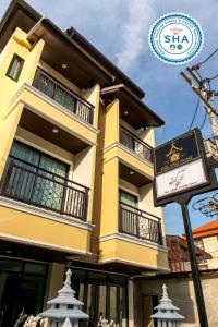 a yellow building with a sign in front of it at Villa Thai Orchid (adult only) in Chiang Mai