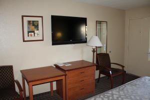 a hotel room with a desk and a television on the wall at Cajon Pass Inn in Cajon Junction
