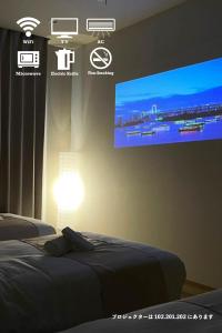 a bedroom with two beds and a tv on the wall at HOTEL CLA-SS HIROSHIMA-DOBASHI in Hiroshima