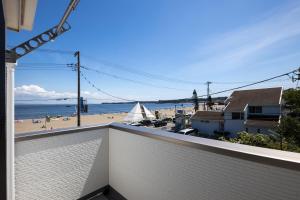 a view of the beach from the balcony of a house at The Beachfront House ビーチフロントの一軒家 4名迄 in Miura