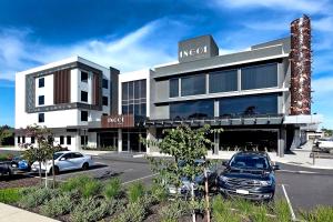 een gebouw met auto's geparkeerd op een parkeerplaats bij Ingot Hotel Perth, Ascend Hotel Collection in Perth