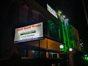 a sign for a main guest house on the side of a building at Milan Guest House in Digha