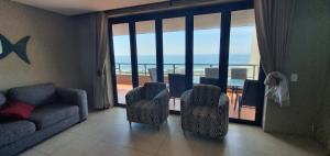 a living room with a couch and a view of the ocean at Accommodation Front - Immaculate 4 Sleeper with Ocean & Harbour Views in Durban